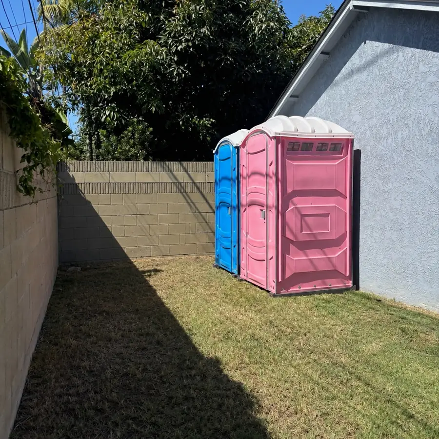 Porta potties placed in a side yard beside a house