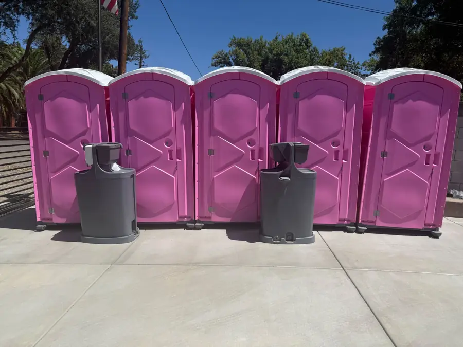 Portable hand-wash stations set in front of a row of event porta potties